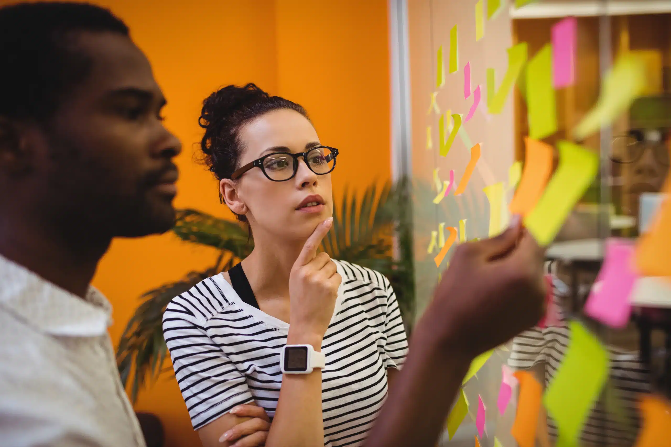 il s'agit d'une photo d'un homme et une femme posant des post it sur un mur